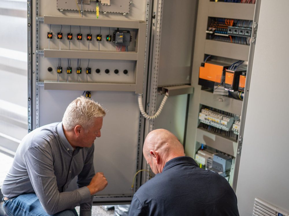 To teknikere fra Vejby A/S gennemgår el-styring og teknik til et pyrolyseanlæg.