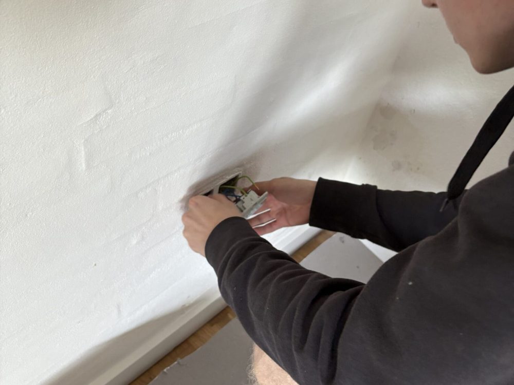 Elektriker fra Vejby A/S monterer ny stikkontakt ved totalrenovering af parcelhus i Skive.