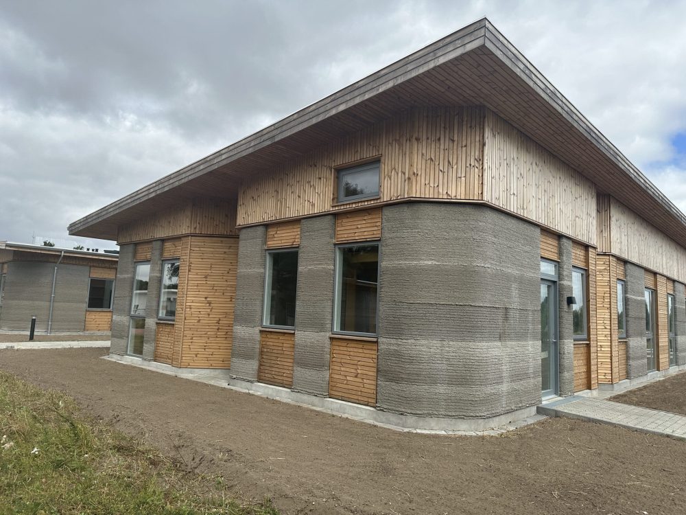 Udvendigt kig på 3D-printet ungdomsbolig med betonvægge og træbeklædning i Holstebro