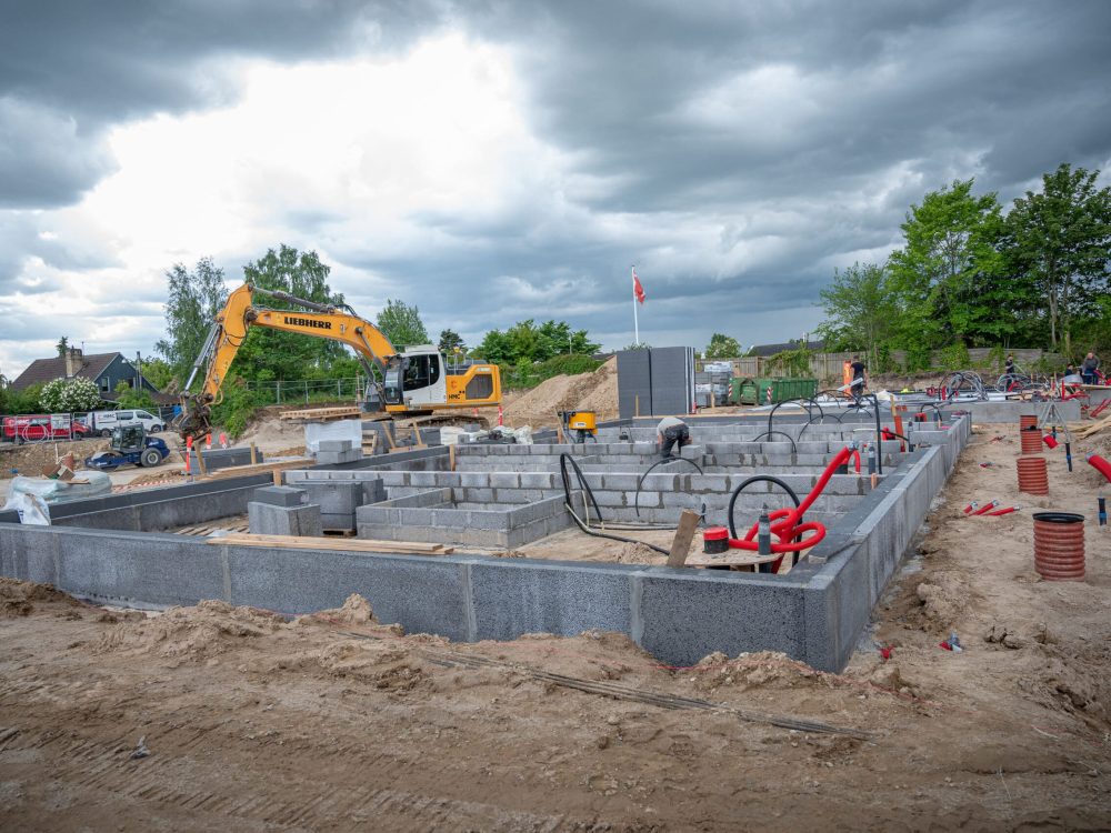 Fundament til rækkehuse i Herlev med el-rør og gravemaskine under opførelse af Vejby A/S.